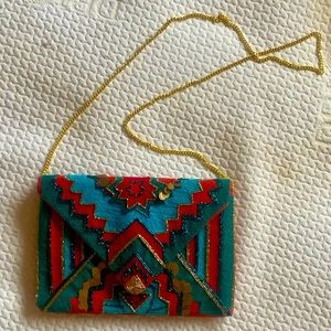 Embroidered canvas clutch in red and green.